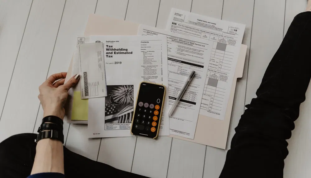 Desk with tax forms, a receipt, and a calculator – manual paperwork.